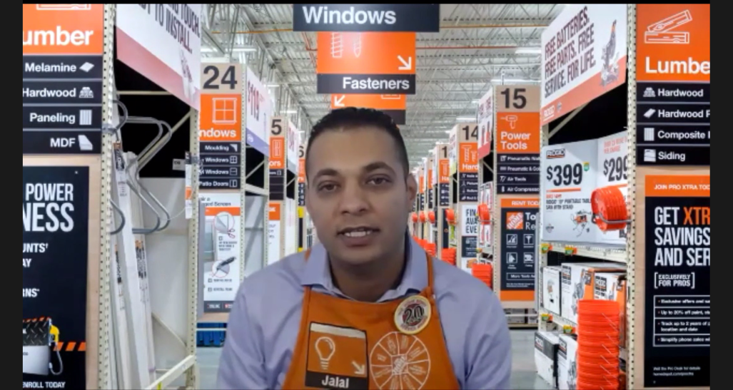 Man in light blue shirt and orange Home Depot apron with Jalal name tag