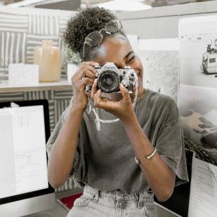 Student intern taking a picture with a camera